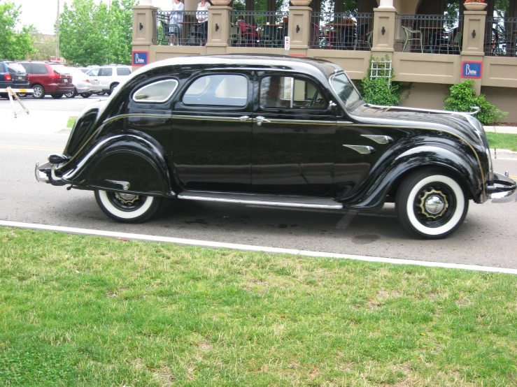 a black and white old fashioned car on a street
