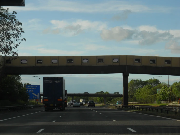 cars and trucks driving underneath an overpass over a street