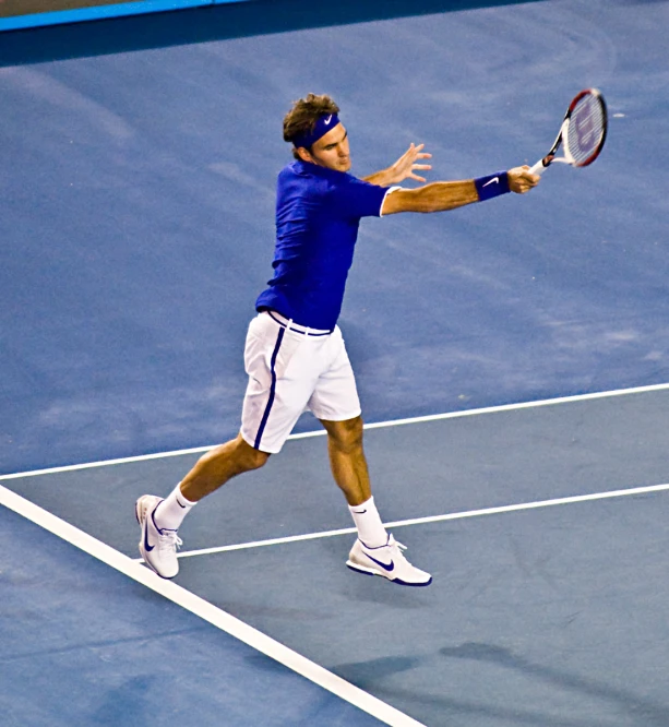 the man is on a court and swinging a racket