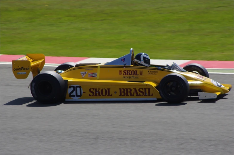 a yellow racing car driving on a road