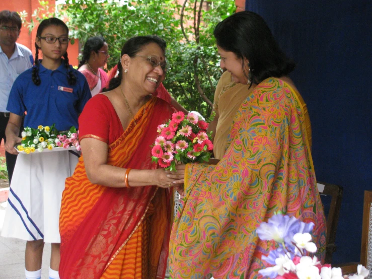 two woman standing next to each other and talking