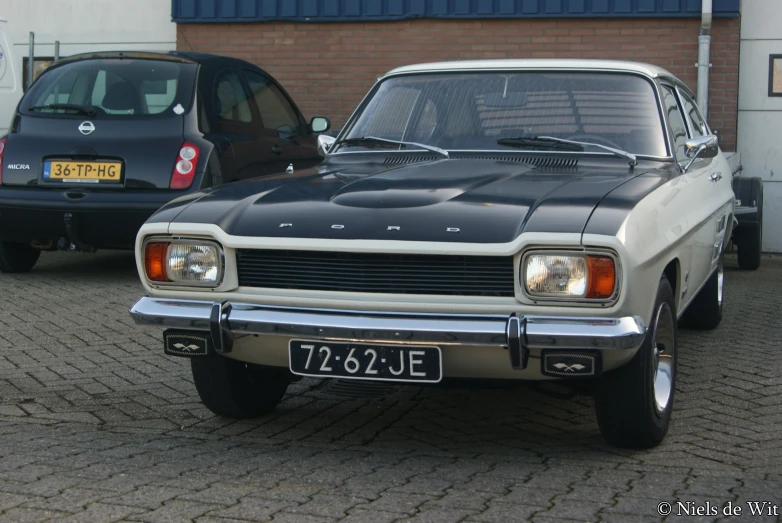 a car that is parked on the road next to a wall