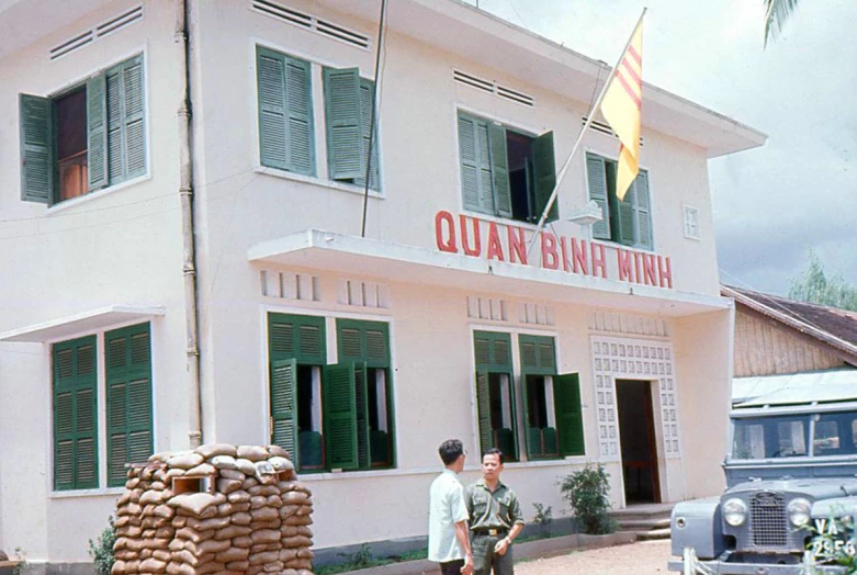 a couple of men walking down a street near a building