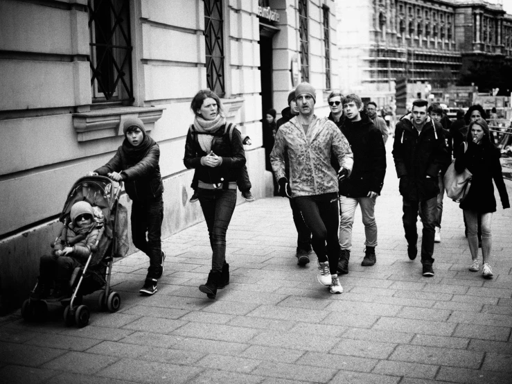 a group of people walking down a street next to buildings