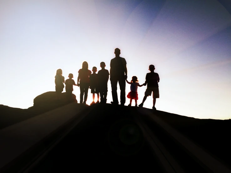 silhouettes of a family with their child holding hands