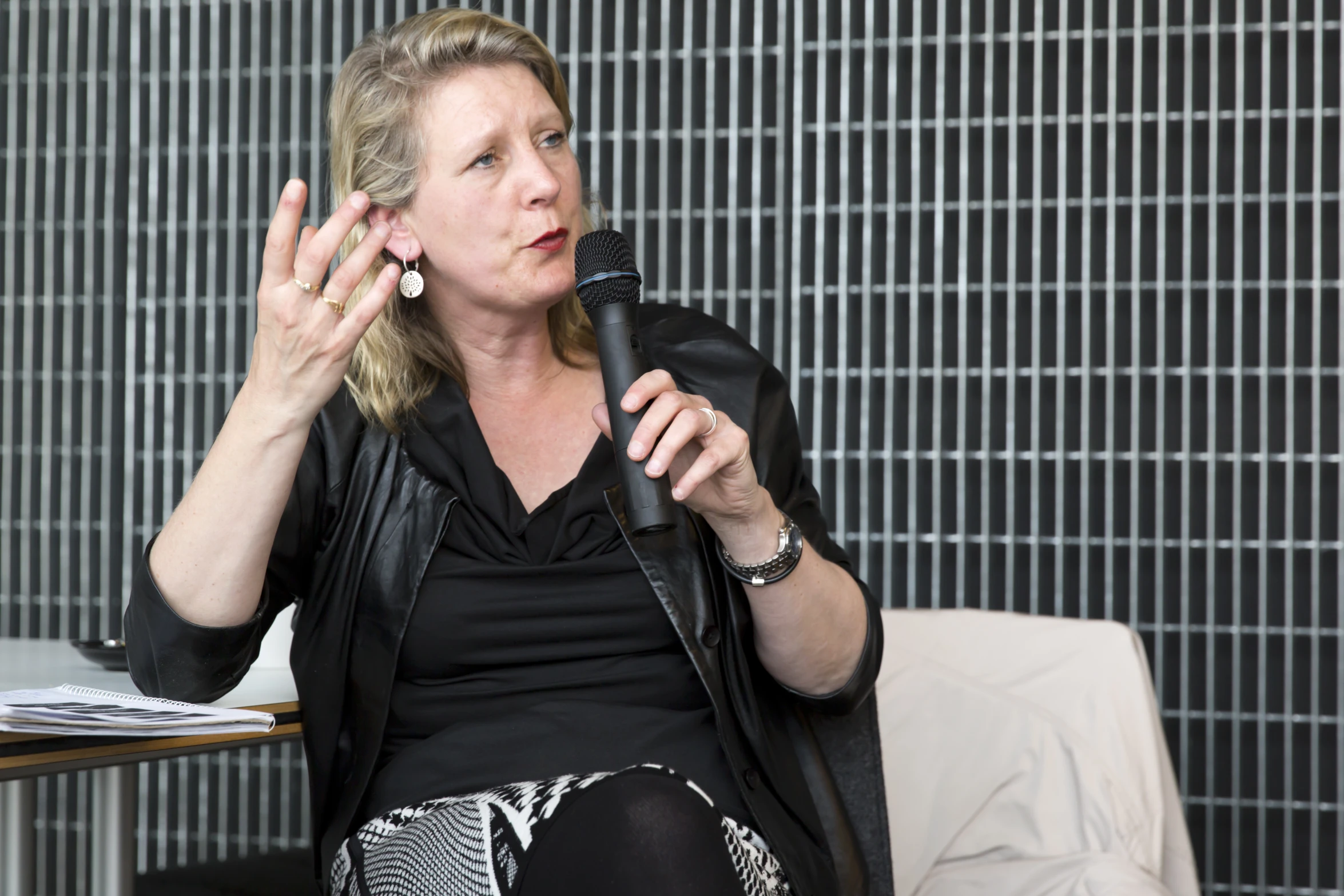 a woman sitting in a chair with a microphone to her ear