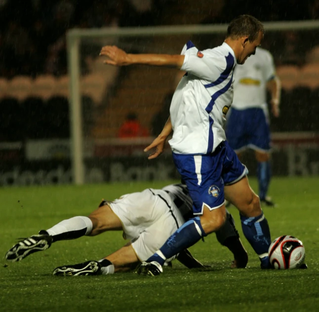 a couple of people on a field playing soccer