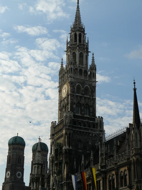 tall clock tower surrounded by smaller buildings under blue sky