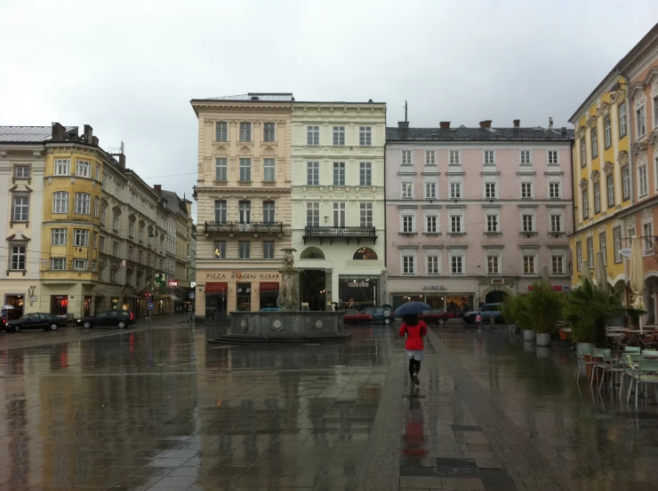 an open city street covered with rain and parked cars