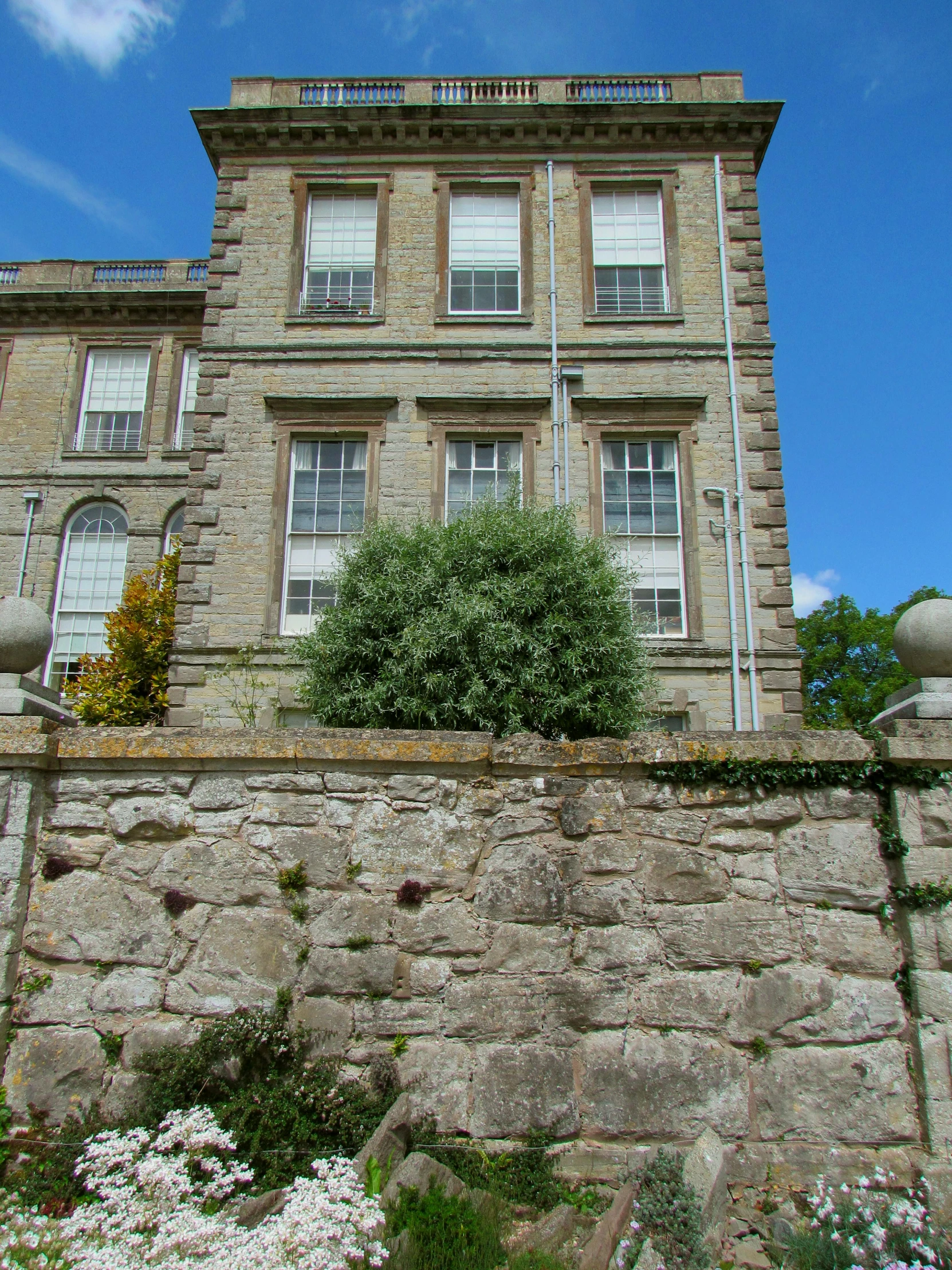 an old brick building next to a stone wall