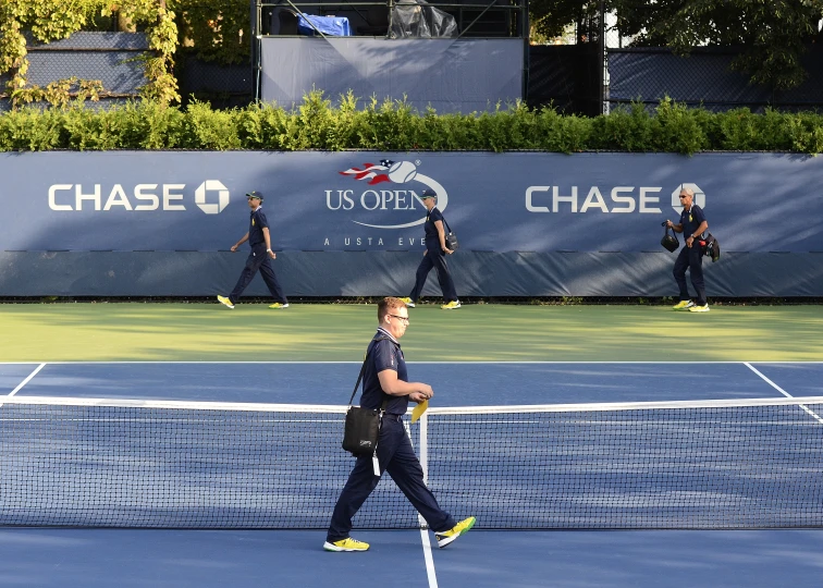 some guys are walking down the tennis court