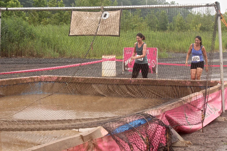 the two women are talking outside in a caged area