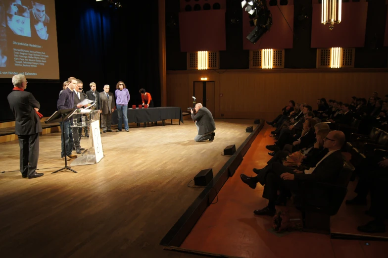 a man standing on top of a hard wood floor next to a podium