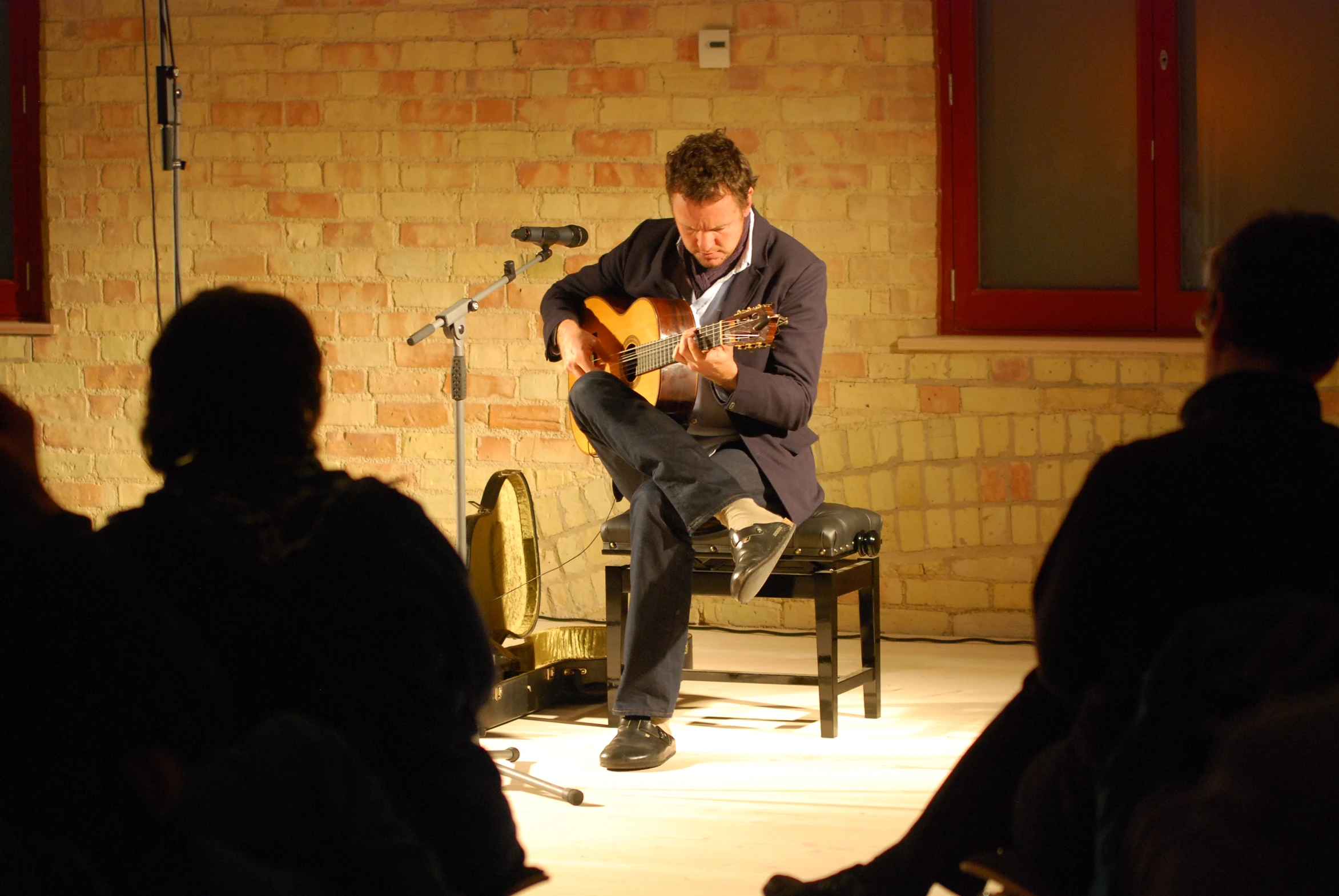 a person sitting on a chair playing a guitar