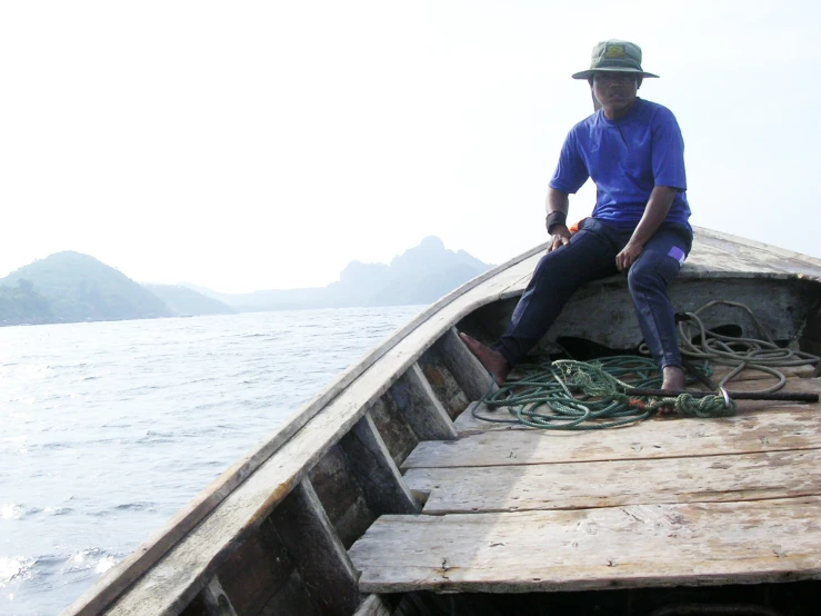 a man sitting on top of a boat while sitting on top of it