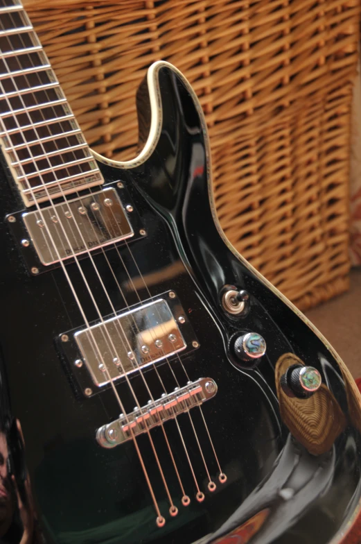 a black guitar is sitting by some baskets