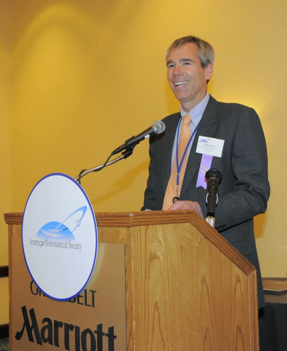 a man standing at a podium in front of a microphone