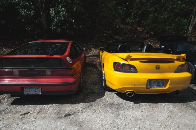 two cars parked in front of some trees