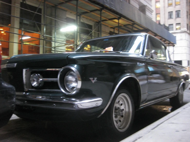 the classic car is parked along the street next to the building