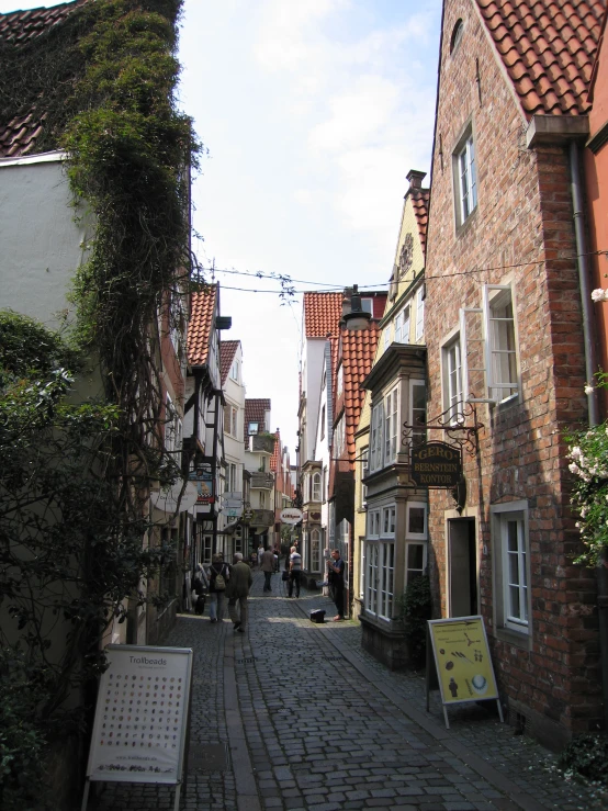 a cobble stone road running between two brick buildings