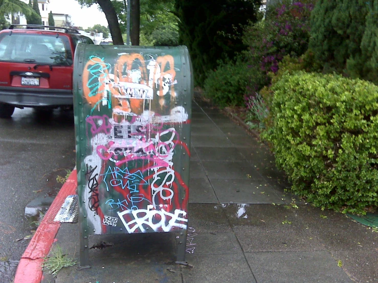 a toilet on a city street next to a bush