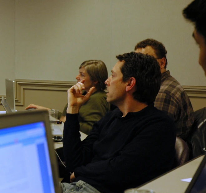 a group of people sitting in front of computers