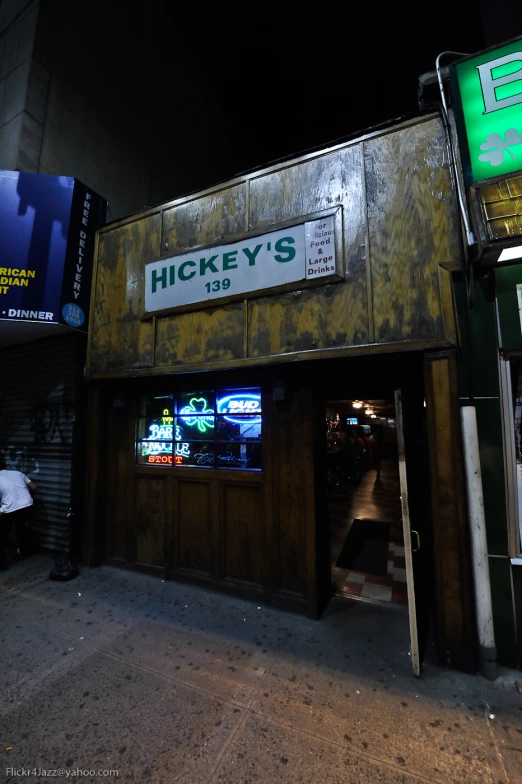 a storefront with the door open at night