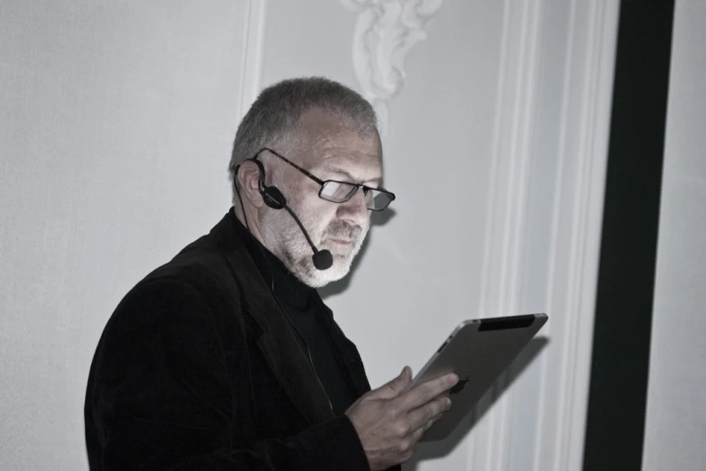 a man holding a tablet while wearing a headset