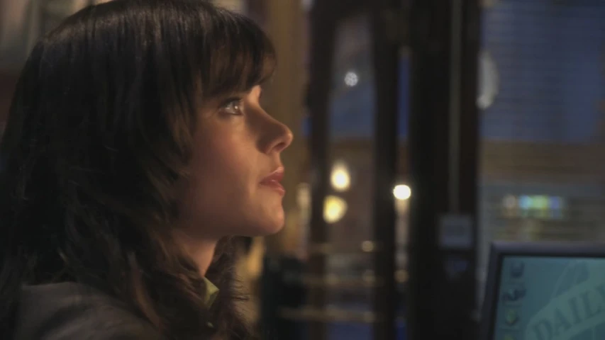 a woman looking over the shoulder of her computer screen