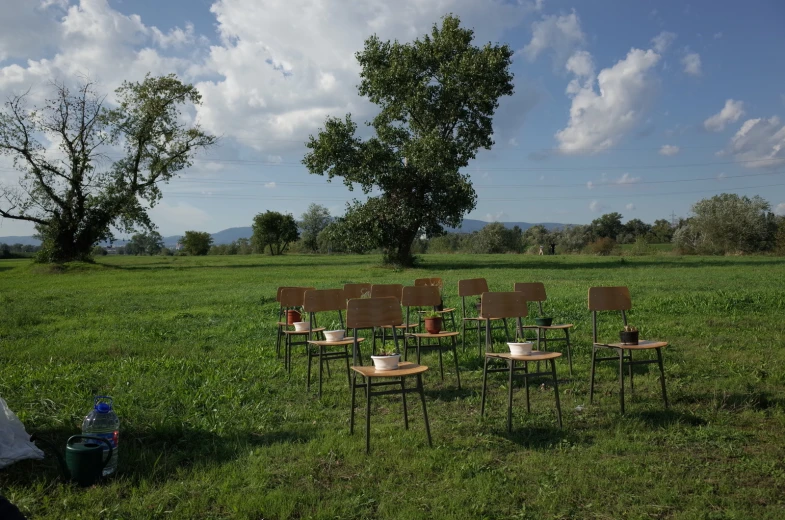 a group of chairs sitting on top of a lush green field