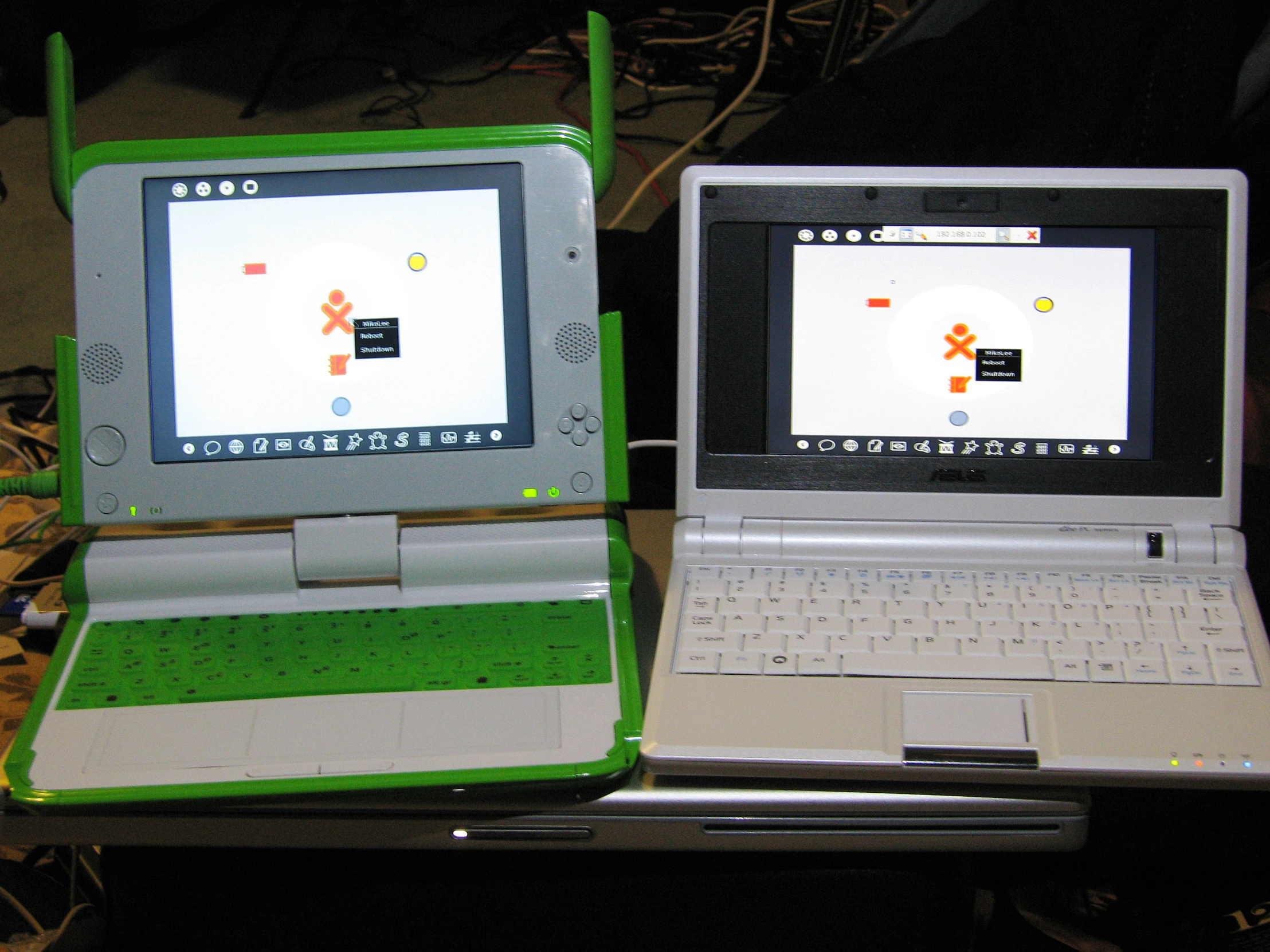 two green and white laptop computers sitting on top of a table