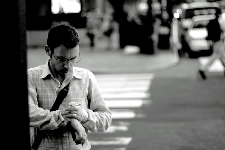 man in the street looking down at his cell phone