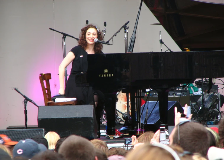 the woman is playing piano on the stage