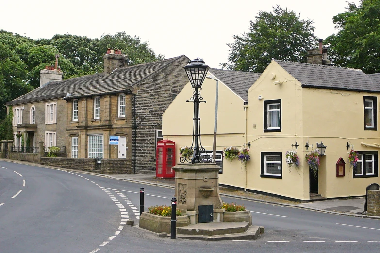 the intersection of a street with a lamp post in front of some pretty buildings