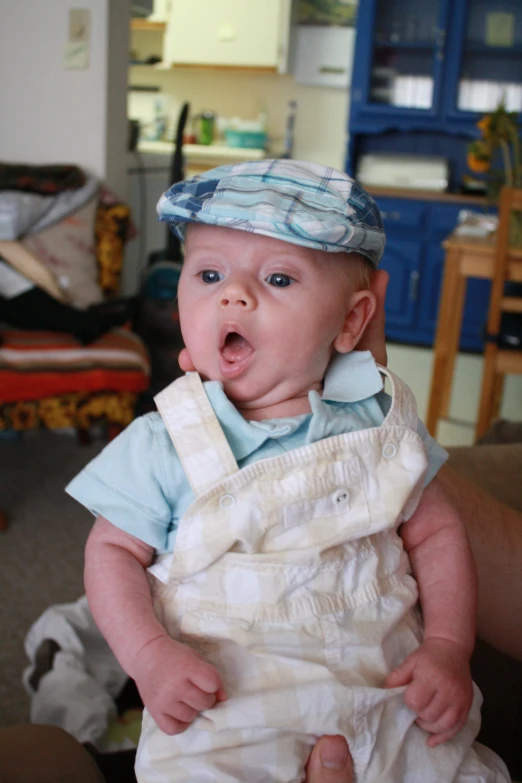 a baby wearing a baby bib making a silly face