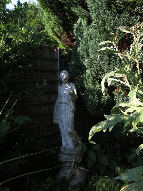 a statue standing in the middle of a garden