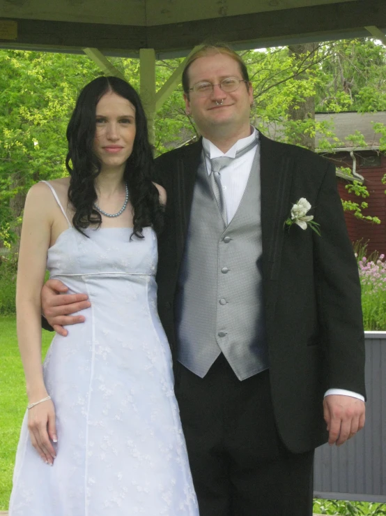 two people posing for a picture in formal wear