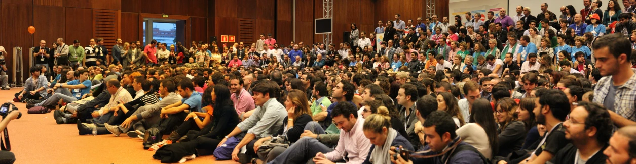 many people sitting down in a hall and waiting