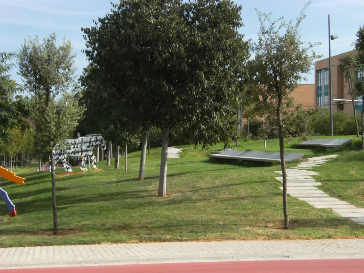 a park in front of a building with s playing on the grass