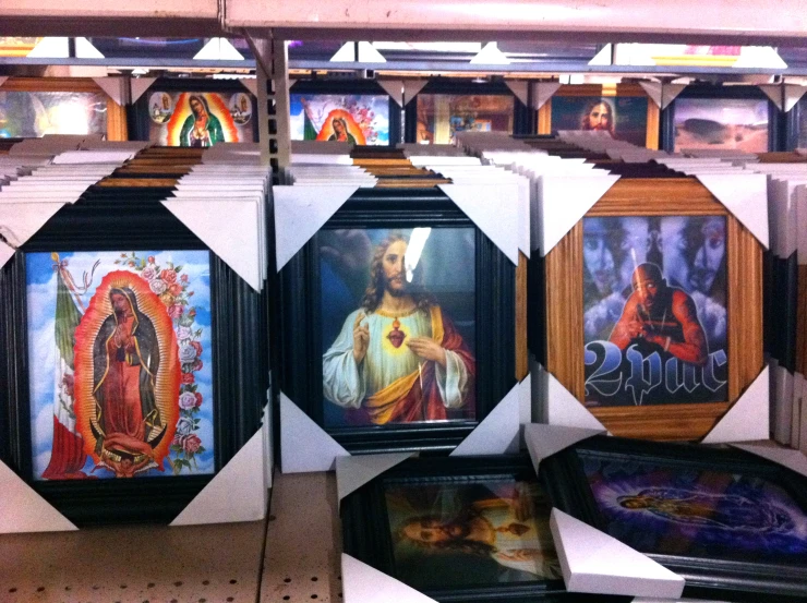 a bunch of framed religious pictures and paintings