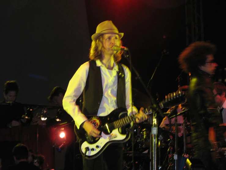 man on stage with his guitar ready to be hit by an overhead sound