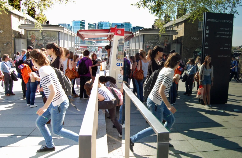 there are people standing on the sidewalk next to the stairs