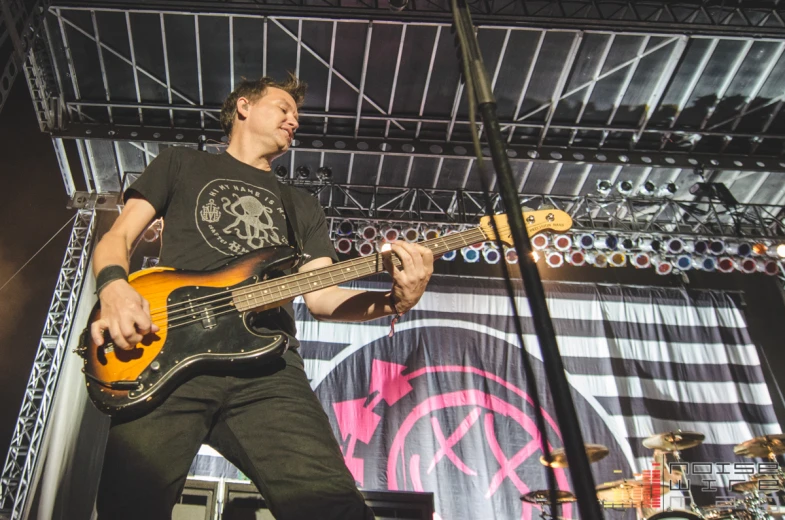 a man that is playing a bass in front of a crowd