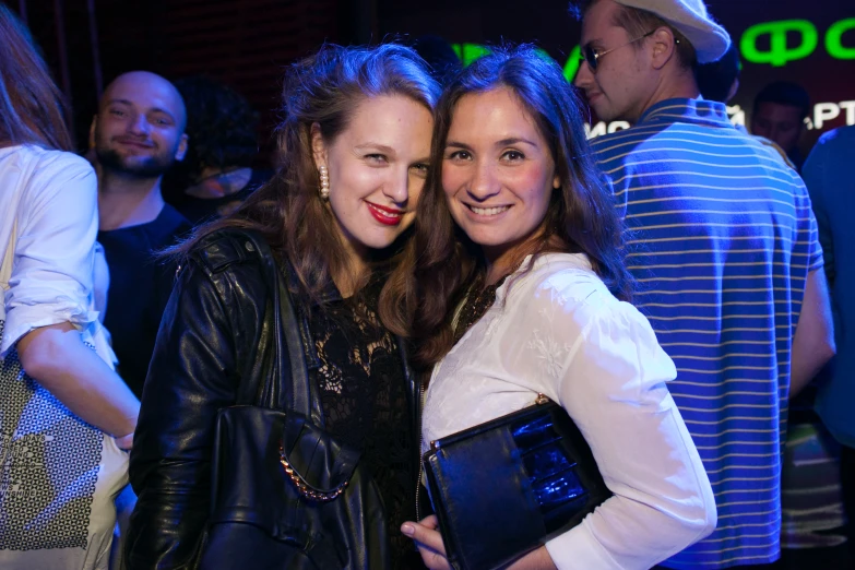 a couple of beautiful ladies smiling in a bar