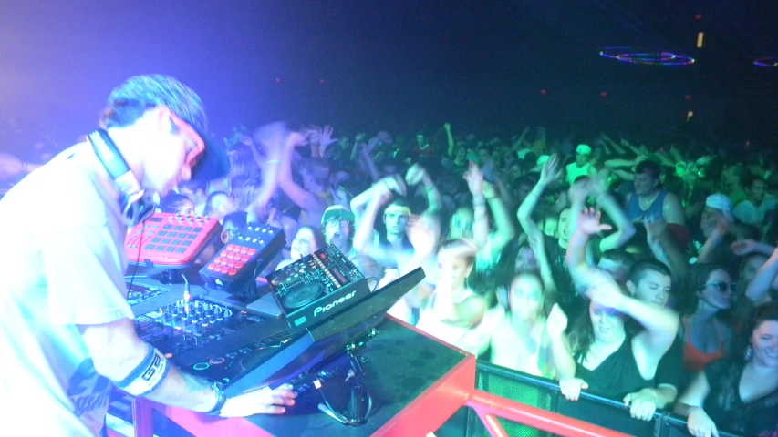 a dj is on a red turntable in front of an audience at a concert