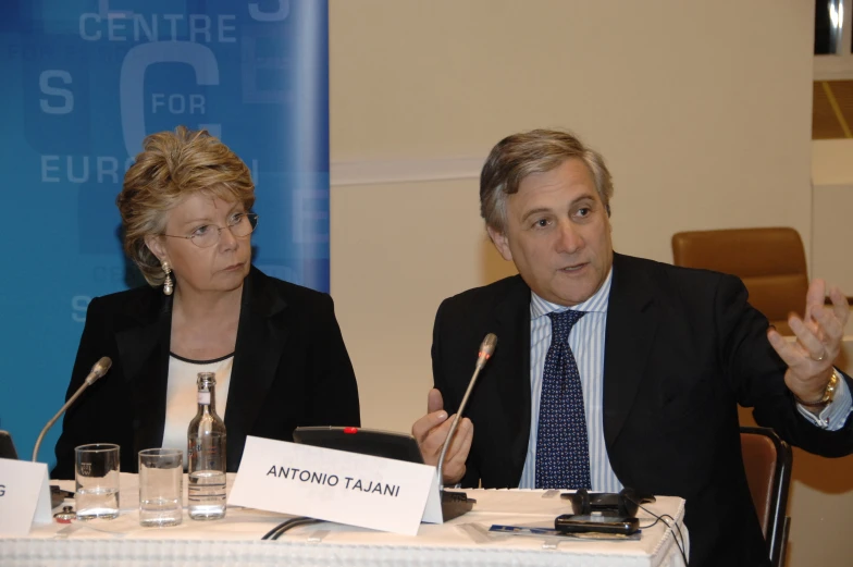 an older man and woman are sitting at a table together