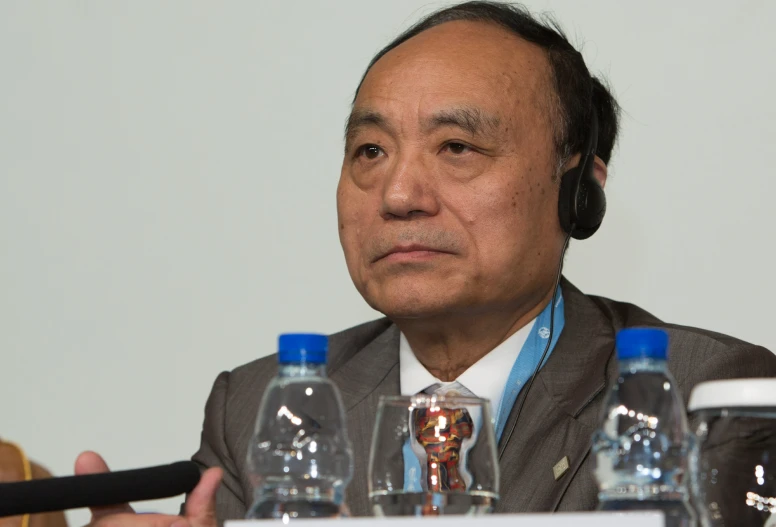 an old man with headphones sitting at a table