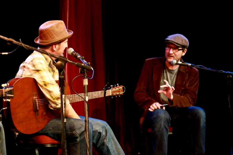 a musician and a man at microphones while the man is on the mic