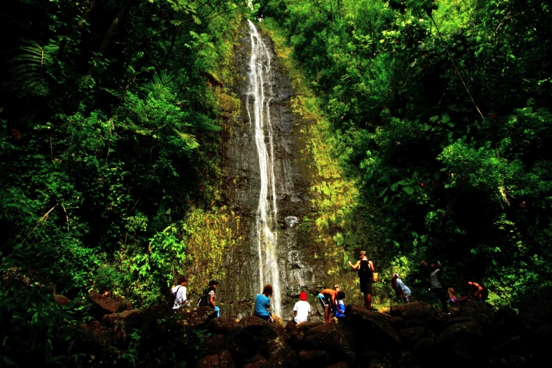 many people are in the foreground standing near a water fall