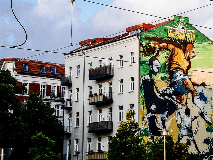 the corner of a large building in front of a tall building with windows and graffiti on it